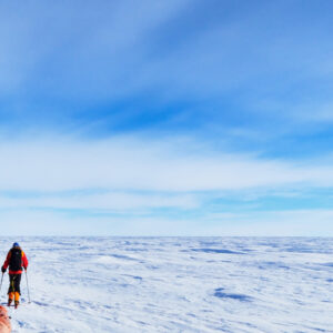 Ski South Pole guest Bob M. pulls his sled across polar plateau.